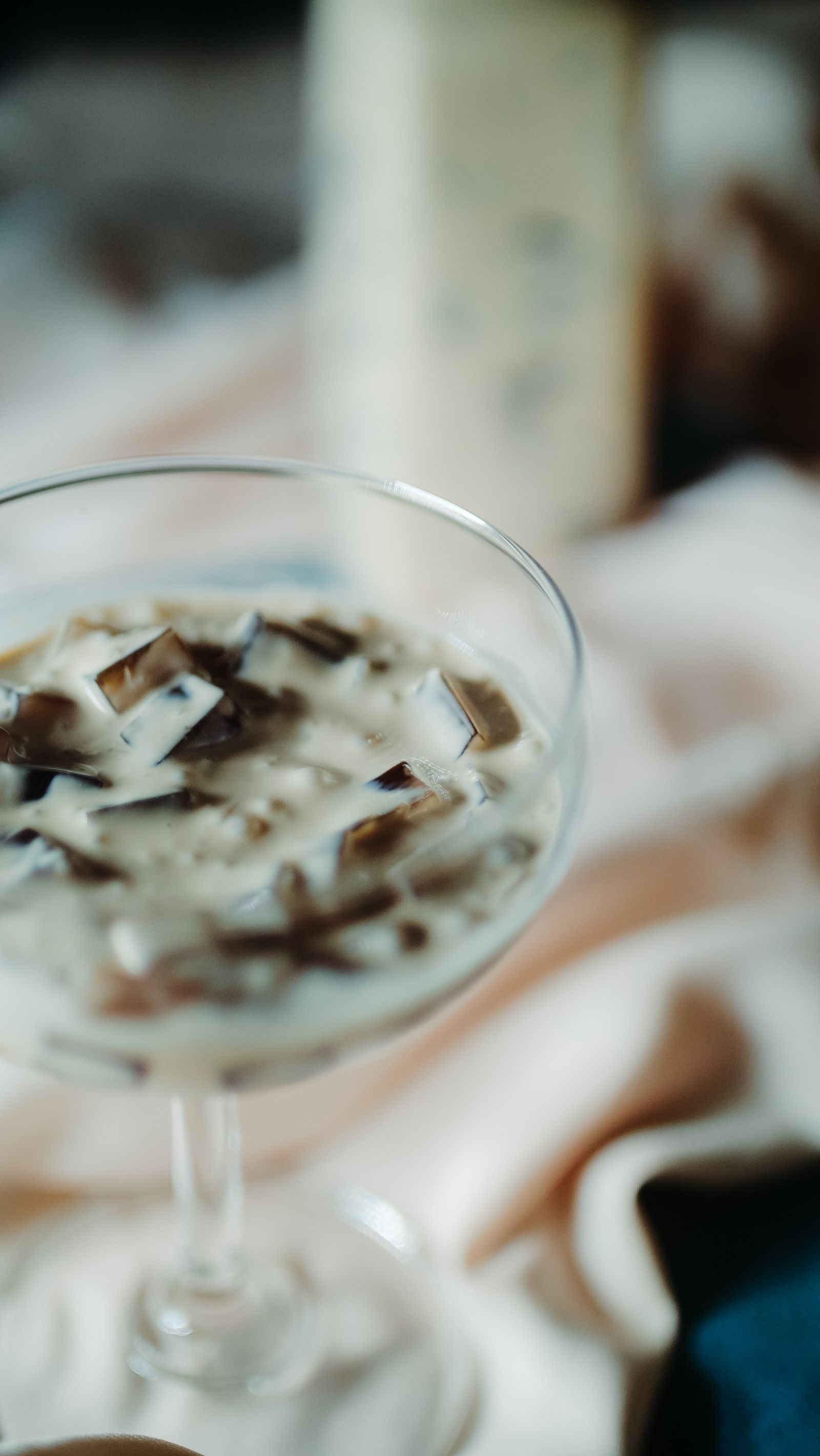 Cubes of dark coffee jelly suspended in cream in a stemmed glass